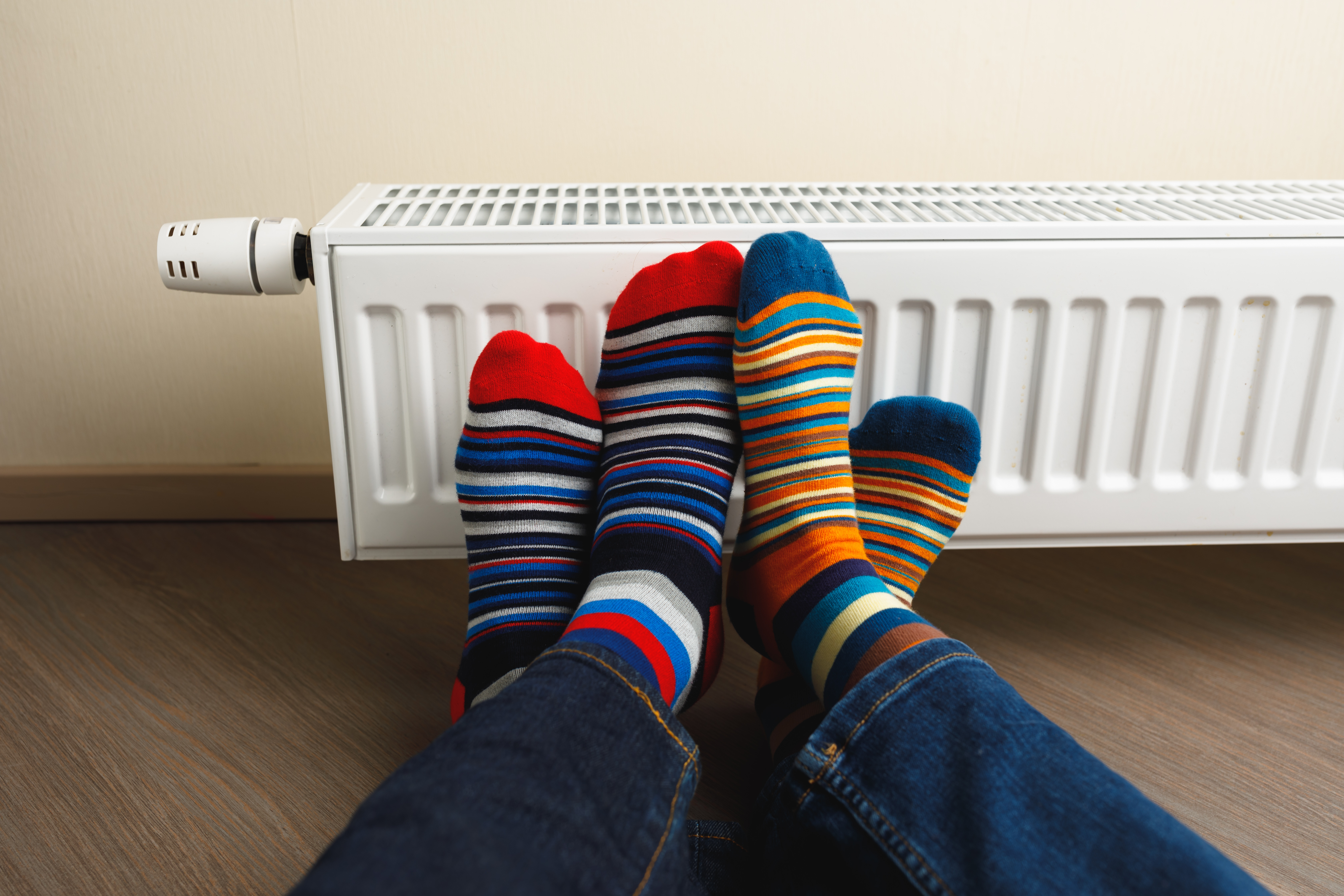 Pieds près d’un radiateur, image associée aux économies d’énergie et au confort dans le logement